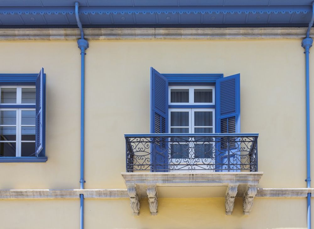 Te windows with opened blue shutters and balcony, Limassol, Cyprus