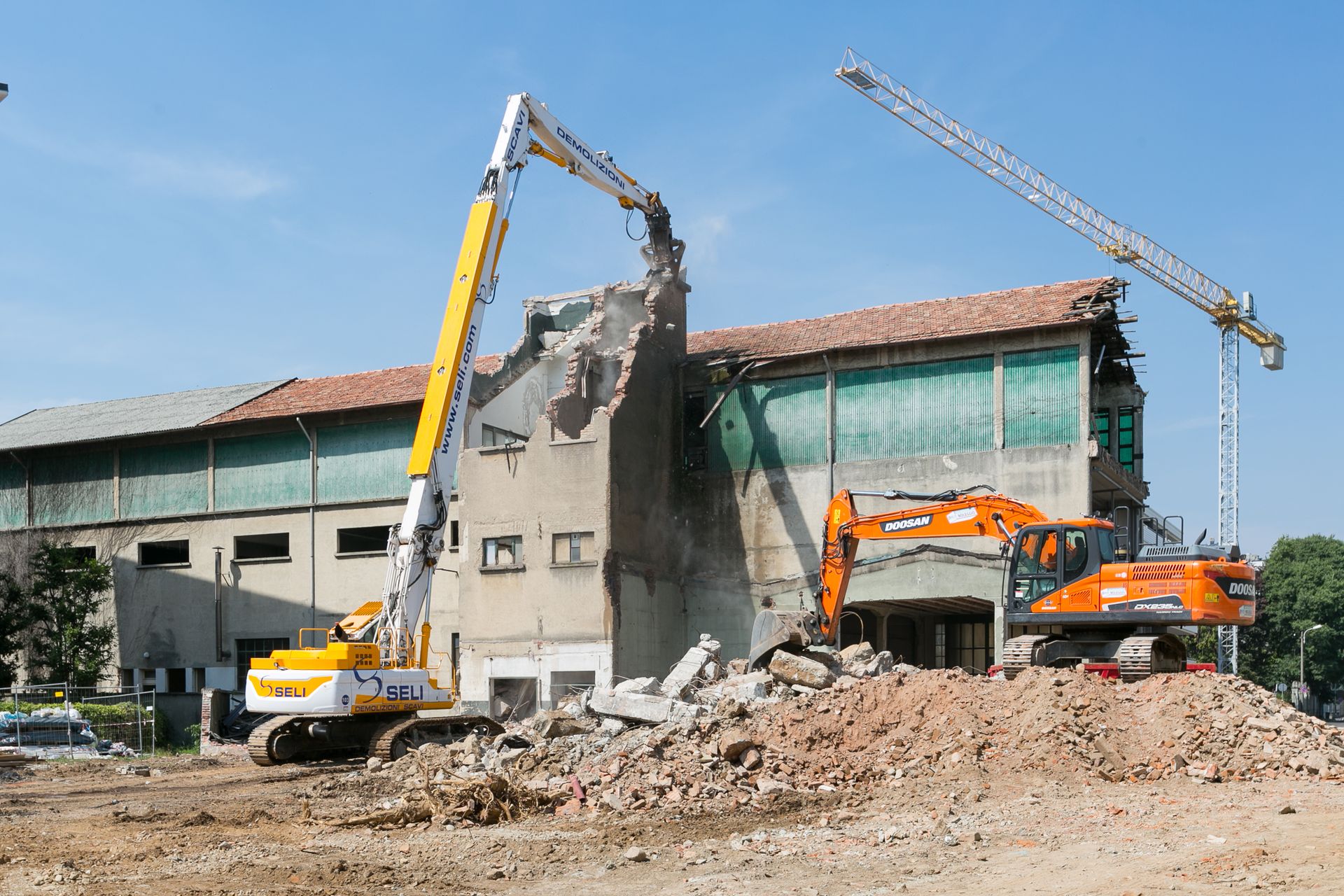 Escavatore da demolizione al lavoro nell’ex stabilimento Brugola OEB